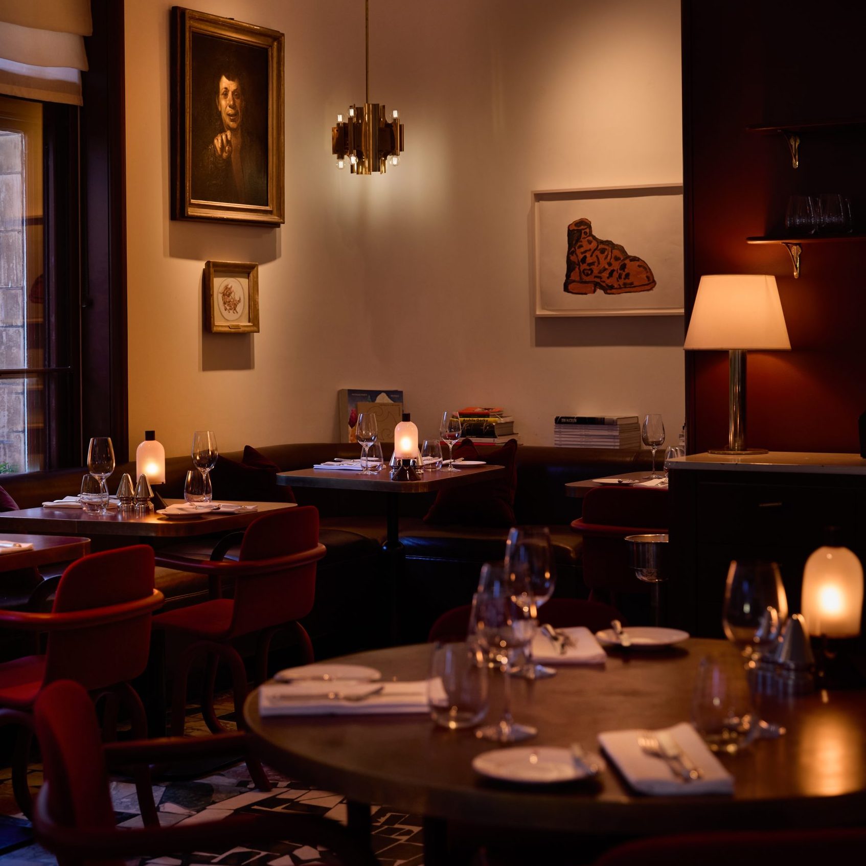 Mount St. Restaurant by night – a view of the restaurant with tables set and art in the background
