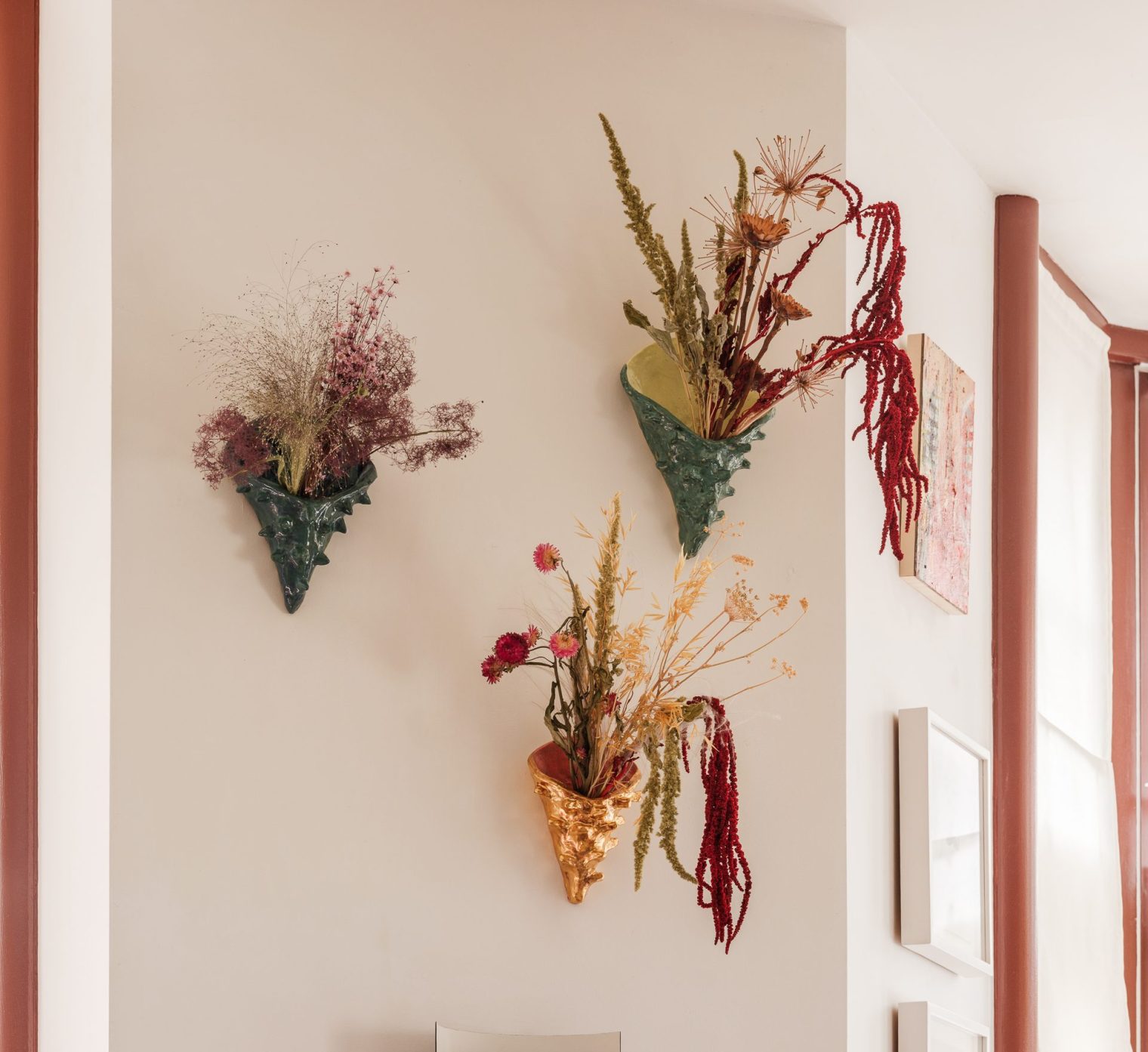 Three earthenware ceramics mounted on a cream wall, by artist Michaela Yearwood-Dan.