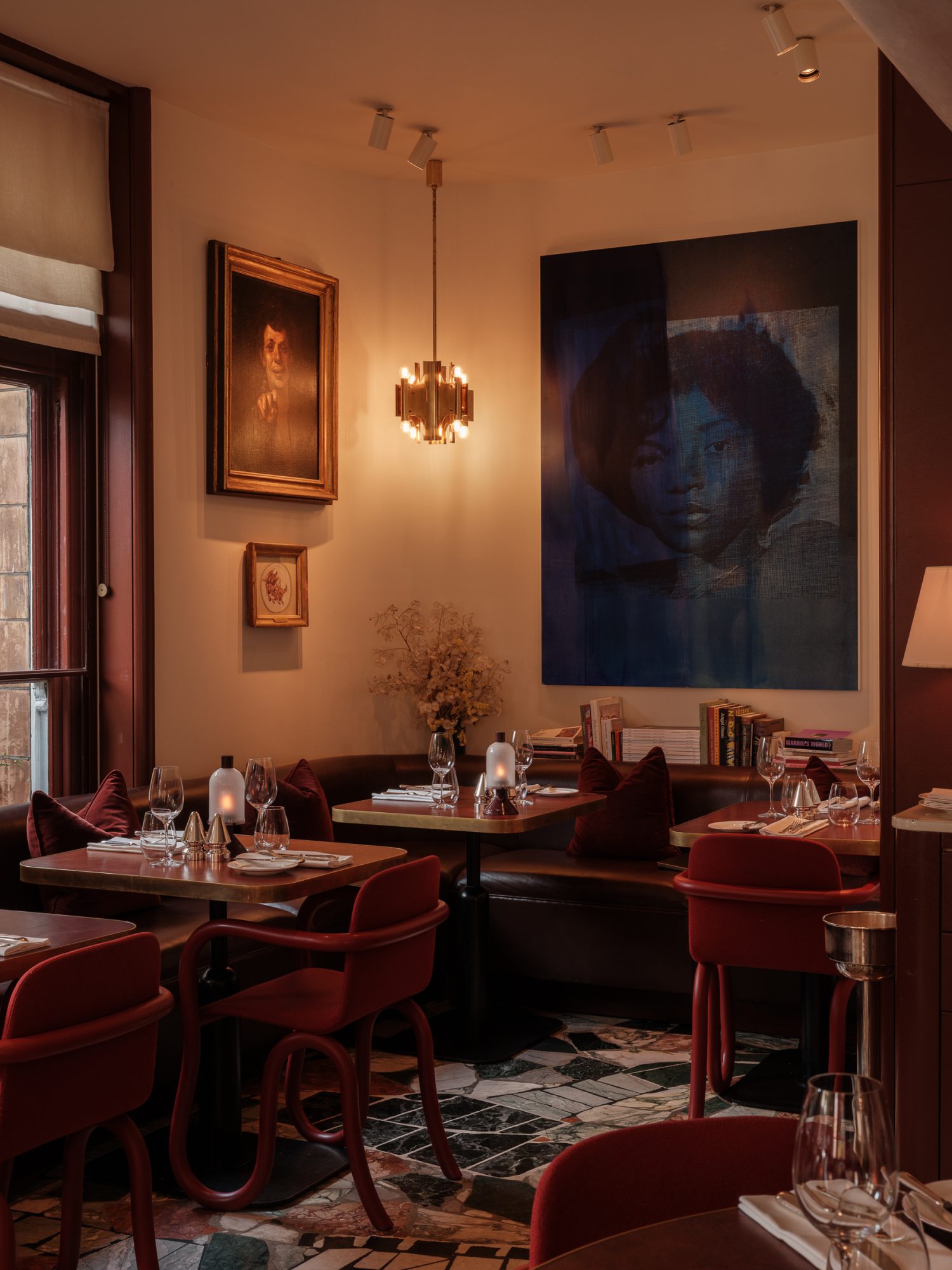 Mount St. Restaurant by night – a view of the restaurant with tables set and art in the background